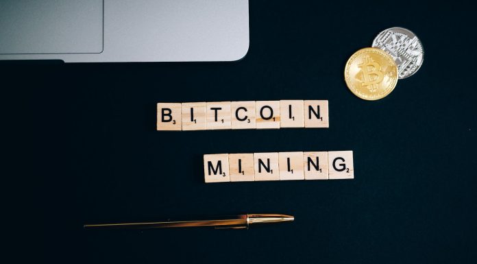 What is Cryptocurrency mining? a bitcoin and pen on a black surface