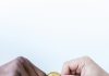 What is Cryptocurrency Lending? close up shot of two people holding a gold coin