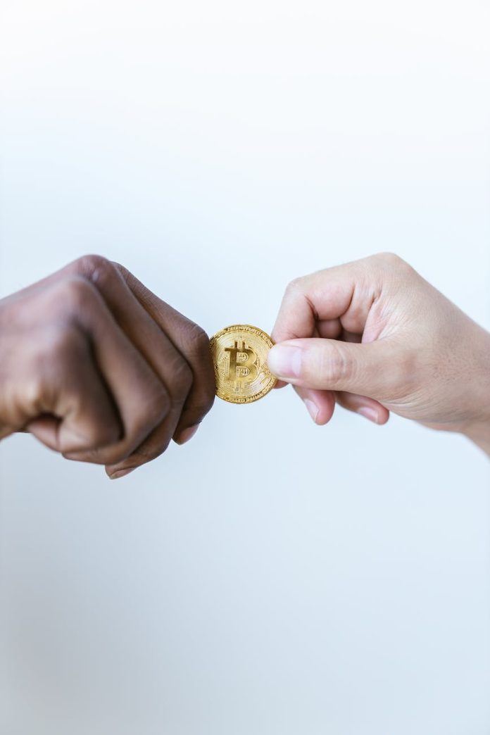 close up shot of two people holding a gold coin