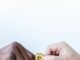 What is Cryptocurrency Lending? close up shot of two people holding a gold coin