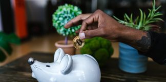 What are Cryptocurrency Airdops? a person putting bitcoin in a piggy bank