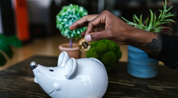What are Cryptocurrency Airdops? a person putting bitcoin in a piggy bank